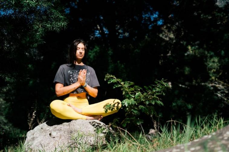 woman meditating in forest