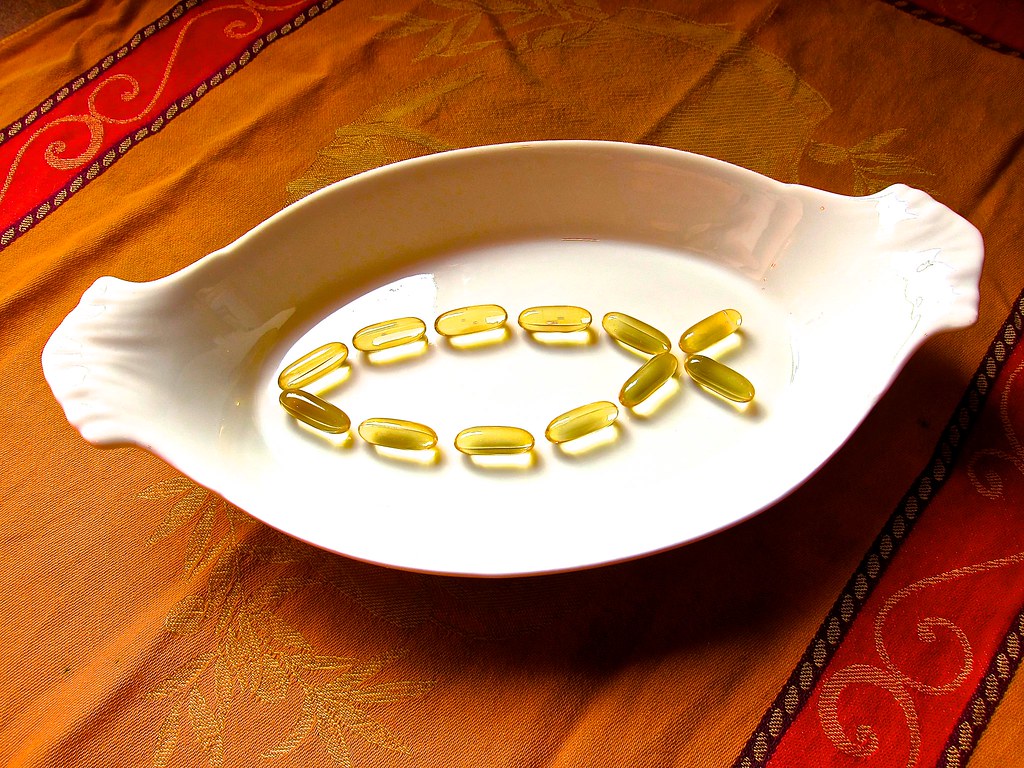 Fish oil supplement capsules in a white dish